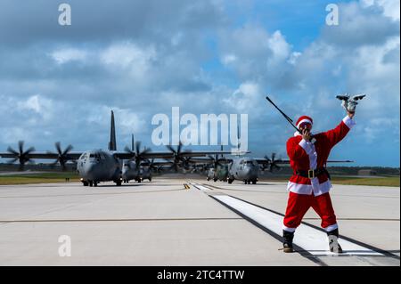 Comandante e pilota di missione dell'USAF Zach "Santa Badger" Overbey, operazione Christmas Drop 2023 (OCD 23), si trova davanti a tre C-130J Super Hercules della U.S. Air Force (USAF) assegnati al 36th Expeditionary Airlift Squadron, una Royal Canadian Air Force (RCAF) 436th Transport Squadron C-130J Super Hercules, un C-130H Hercules della Japan Air Self-Defense Force (JASDF) assegnato al 401st Tactical Airlift Squadron, e un C-130H Hercules della Republic of Korea Air Force (ROKAF) assegnato al 251st Airlift Squadron a supporto di un OCD 23 Elephant Walk presso Andersen Air Force base, Guam, 9 dicembre 202 Foto Stock