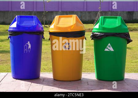 Set di contenitori in plastica, verde, giallo e blu. Contenitori per rifiuti di colore diverso per rifiuti generici, compostabili e riciclabili. Foto Stock