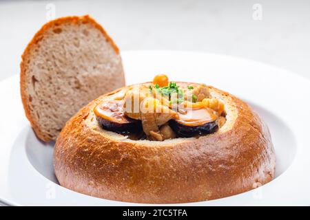 stufato con carne di maiale, ceci e sausge in pane Foto Stock