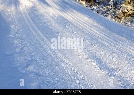 Pista per auto sulla neve su una strada Foto Stock