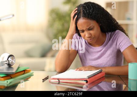 Studente nero preoccupato che studiava memorizza appunti a casa Foto Stock