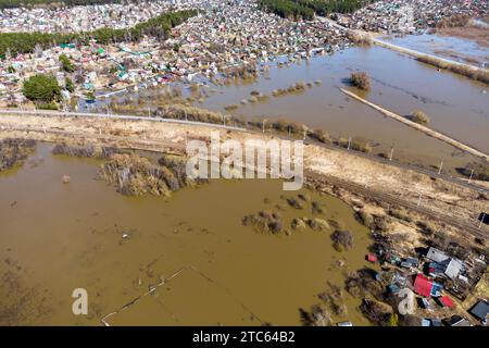 Vista aerea di una ferrovia che attraversa una campagna allagata durante le inondazioni primaverili Foto Stock