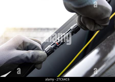 Primo piano delle mani per chiudere un connettore del cavo del pannello solare Foto Stock