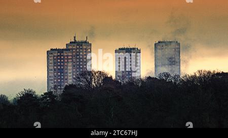 Glasgow, Scozia, Regno Unito. 11 dicembre 2023. Tempo nel Regno Unito: Cloudy Dawn ha assistito a una giornata di ventosa e umida sull'ovest della città. Come l'impianto di rifiuti di concil nel parco dawsholm fornisce drammi per le torri del consiglio di Maryhill. Credit Gerard Ferry/Alamy Live News Foto Stock