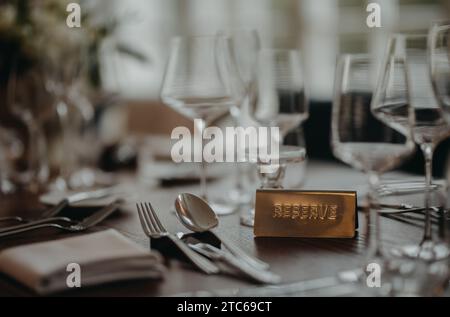 Prenotazione al tavolo, cartello riservato al tavolo, targa. Elegante e romantico tavolo per ricevimenti nuziali al coperto. o per il ristorante. Foto Stock