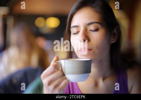 Il cliente del ristorante puzza di caffè dalla tazza rilassante Foto Stock