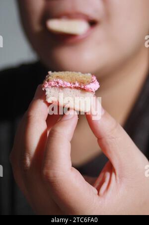 Donna che regge una tazza di torta, sfondo morbido sfocato Foto Stock