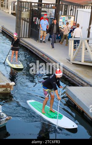 Santa Barbara, California, Stati Uniti, 10 dicembre 2023. Due paddle boarder a Santa Hats alla PARADE OF LIGHTS KAYAK & SUP al porto di Santa Barbara il 10 dicembre 2023, nell'ambito del Parade of Lights Festival. Dozzine di persone vestite da Babbo Natale ed Elfi e cavalcate su paddle board e kayak attraverso il porto. (Immagine di credito: © Amy Katz/ZUMA Press Wire) SOLO USO EDITORIALE! Non per USO commerciale! Crediti: ZUMA Press, Inc./Alamy Live News Foto Stock