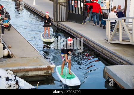 Santa Barbara, California, Stati Uniti, 10 dicembre 2023. Due paddle boarder a Santa Hats alla PARADE OF LIGHTS KAYAK & SUP al porto di Santa Barbara il 10 dicembre 2023, nell'ambito del Parade of Lights Festival. Dozzine di persone vestite da Babbo Natale ed Elfi e cavalcate su paddle board e kayak attraverso il porto. (Immagine di credito: © Amy Katz/ZUMA Press Wire) SOLO USO EDITORIALE! Non per USO commerciale! Crediti: ZUMA Press, Inc./Alamy Live News Foto Stock