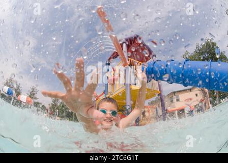 Un ragazzo che giocava sotto una fontana in una piscina il 7 luglio 2007 a Fort Collins, Colorado. Foto Stock