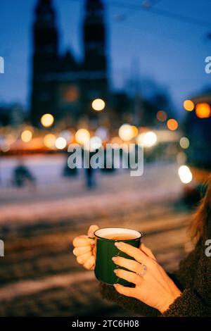 Serata di neve nella Praga di natale, scaldateci le mani su una tazza di tè Foto Stock