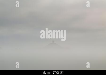 Glastonbury Tor che emerge da una mattina nebbiosa, Somerset, Inghilterra. Estate (agosto) 2023. Foto Stock