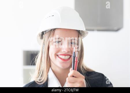 Giovane ingegnere donna con casco in un negozio di lavoro Foto Stock