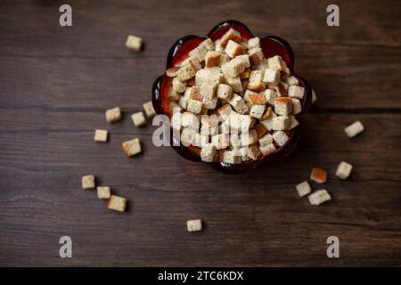 crostini di pane da rifornire in un recipiente rosso su fondo di legno Foto Stock