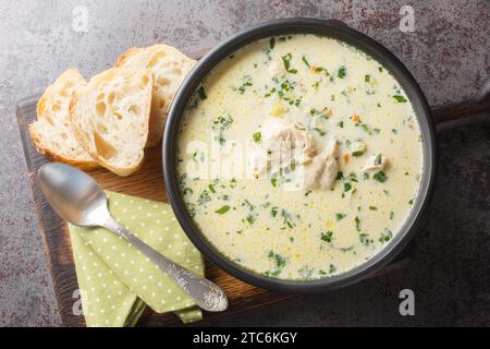 Zuppa di pollo acida fatta in casa con panna acida e verdure in un recipiente sul tavolo. Vista superiore orizzontale dall'alto Foto Stock