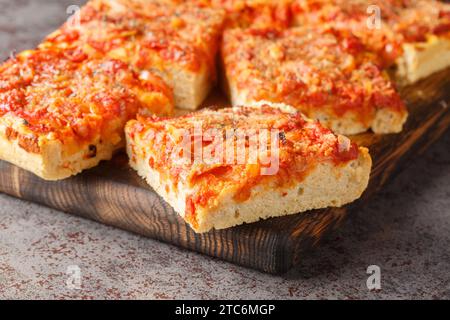 Sfincione siciliano pizza italiana focaccia preparata con cipolle, salsa di pomodoro, acciughe, formaggio caciocavallo e pangrattato primo piano sul Wo Foto Stock