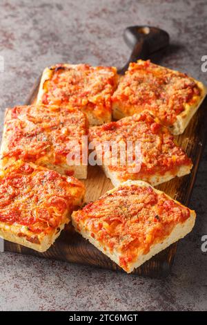 Sfincione Siciliano è una pizza siciliana condita con croccanti pangrattati, formaggio grattugiato e origano da vicino sulla tavola di legno sul tavolo. Ver Foto Stock