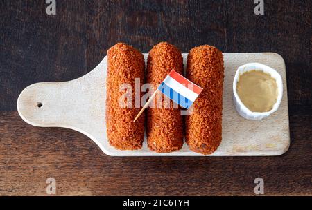 Tradizionale kroketten olandese servito con senape, un popolare spuntino fast food fritto in profondità Foto Stock