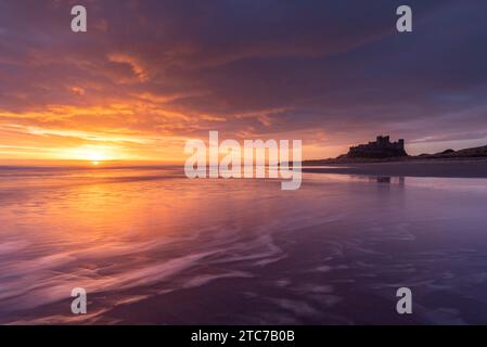 Splendida alba sopra il castello di Bamburgh sulla costa del Northumberland, Inghilterra. Primavera (marzo) 2023. Foto Stock