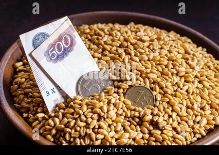 Grano di grano in una ciotola con valuta russa. Scambiate i prezzi per il concetto di grano. Concetto di scambio di grano o scambio di grano Foto Stock