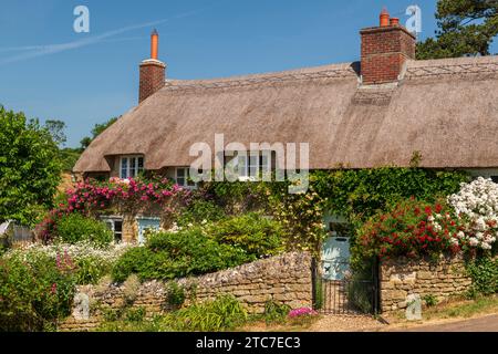 Idilliaco cottage con tetto in paglia e colorato giardino fiorito nel villaggio di Powerstock, Dorset, Inghilterra. Estate (giugno) 2023. Foto Stock