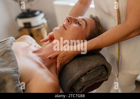 Donna che riceve un massaggio rilassante al collo in una spa con le mani di un terapista sulla spalla. Salone di bellezza immagine concept Hotel benessere Foto Stock