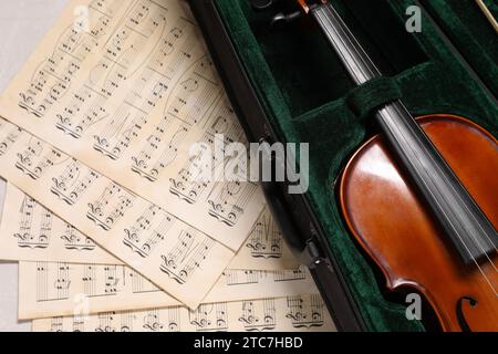 Violino in astuccio e spartiti musicali sul tavolo, vista dall'alto Foto Stock