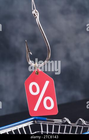 Segno di percentuale su un gancio da pesca con carrello. Shopaolismo, sconti sul concetto di dipendenza Foto Stock