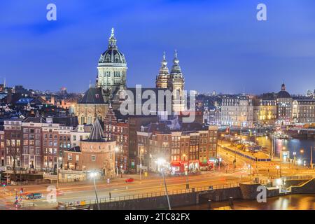 Amsterdam, paesaggio urbano della città olandese sul quartiere del centro storico con la Basilica di San Nicola all'ora blu. Foto Stock