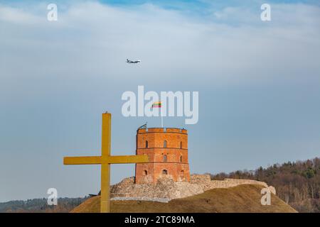 Una foto della torre del castello di Gediminas mentre un aereo vola sopra Foto Stock