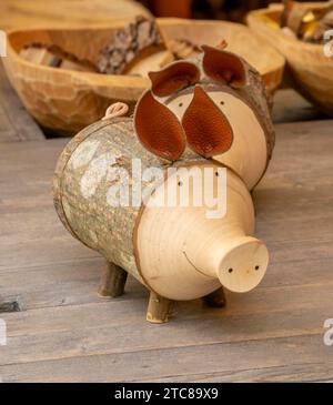 Figurina di maiale in legno. Decorazione delle camere fatta a mano. Giocattolo maiale con orecchie in pelle Foto Stock