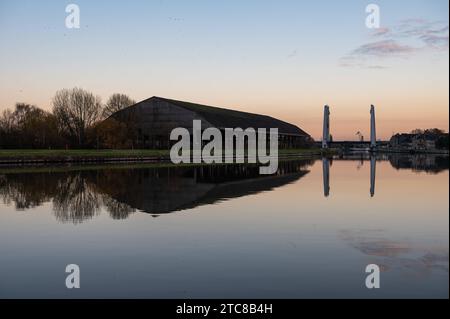 Vilvoorde, regione del Brabante fiammingo, Belgio, 28 novembre 2023 - riflessione di impianti industriali abbandonati e attivi e magazzini nel canale credito: Imago/Alamy Live News Foto Stock