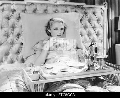 Donna gode della colazione a letto (OV2023 21) Foto Stock
