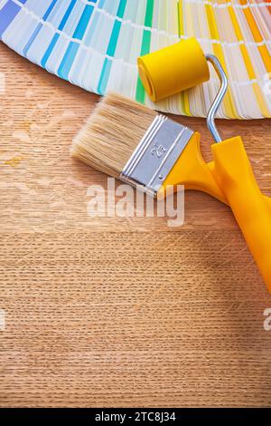 Spazzola a rullo per verniciatura e guida alla tavolozza colori pantone sul concetto di costruzione di pannelli in legno Foto Stock