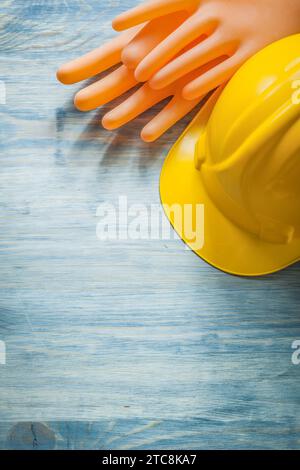 Composizione di guanti dielettrici casco da costruzione su tavola di legno concetto di elettricità Foto Stock