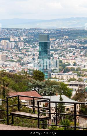 Viaggia verso la Georgia - panchina presso il punto panoramico sul Monte Mtatsminda e sopra la vista della città di Tbilisi sullo sfondo il giorno autunnale Foto Stock