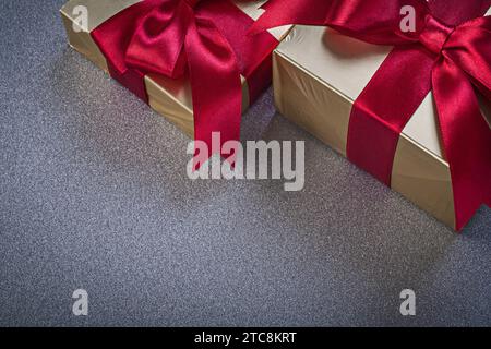 Confezioni regalo con nastri rossi su sfondo grigio per le vacanze Foto Stock