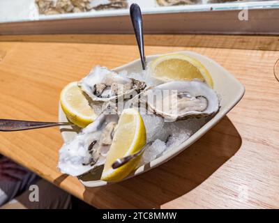 Deliziose ostriche crude su mezzo guscio in un ristorante Foto Stock