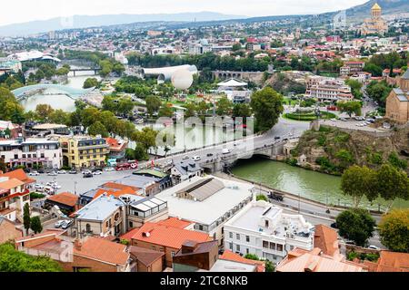 Tbilisi, Georgia - 23 settembre 2023: Vista sopra la città di Tbilisi con il ponte Metechi dalla fortezza di Narikala in un nuvoloso giorno autunnale Foto Stock