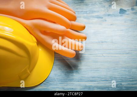 Guanti dielettrici casco da costruzione su tavola di legno concetto di elettricità Foto Stock