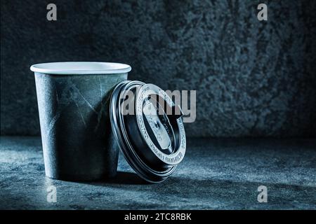 Tazza di carta da caffè nera aperta su sfondo grigio scuro Foto Stock