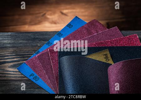 Assortimento di carta vetrata su fondo in legno vintage Foto Stock