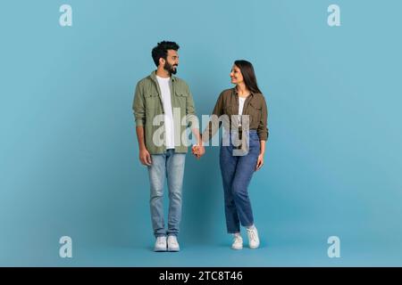 Romantica coppia millenaria indiana in posa su sfondo blu studio Foto Stock