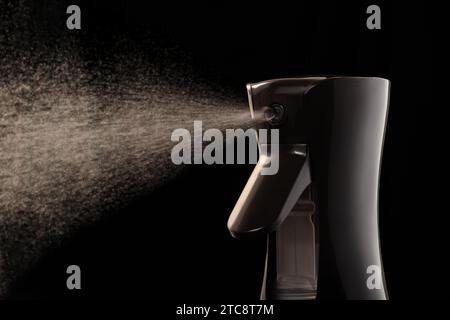 Primo piano di una pistola a spruzzo su sfondo nero. Spruzzare acqua. Pistola spray per parrucchieri. Foto Stock