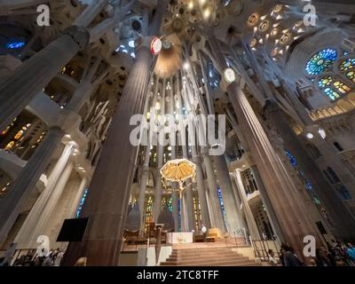 Barcellona, Spagna - 27 agosto 2023: La luce inonda attraverso le vetrate colorate dell'altare della basilica de la Sagrada Familia progettata da Ant Foto Stock