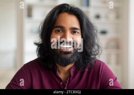 Ritratto di un giovane indiano bello e allegro che guarda la macchina fotografica Foto Stock