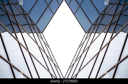 Riflessi distorti nelle finestre specchiate di un edificio moderno, schema architettonico astratto di colore geometrico blu Foto Stock