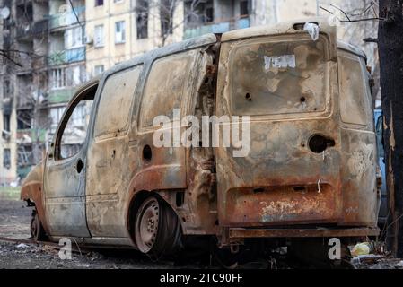 Auto danneggiate e saccheggiate in una città in Ucraina durante la guerra con la Russia Foto Stock