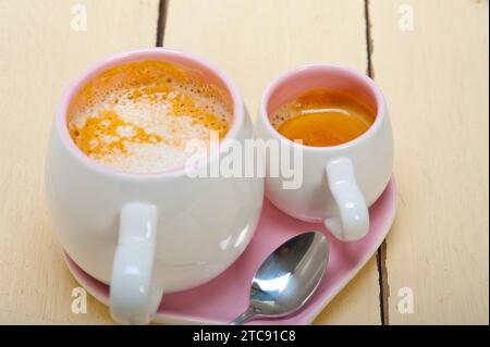 Caffè espresso servito su un piatto rosa a forma di cuore Foto Stock