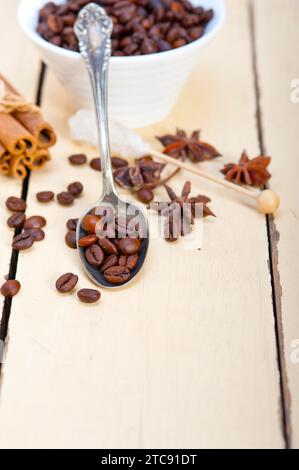 Caffè, zucchero e spezie su un cucchiaio d'argento su un tavolo rustico in legno bianco Foto Stock